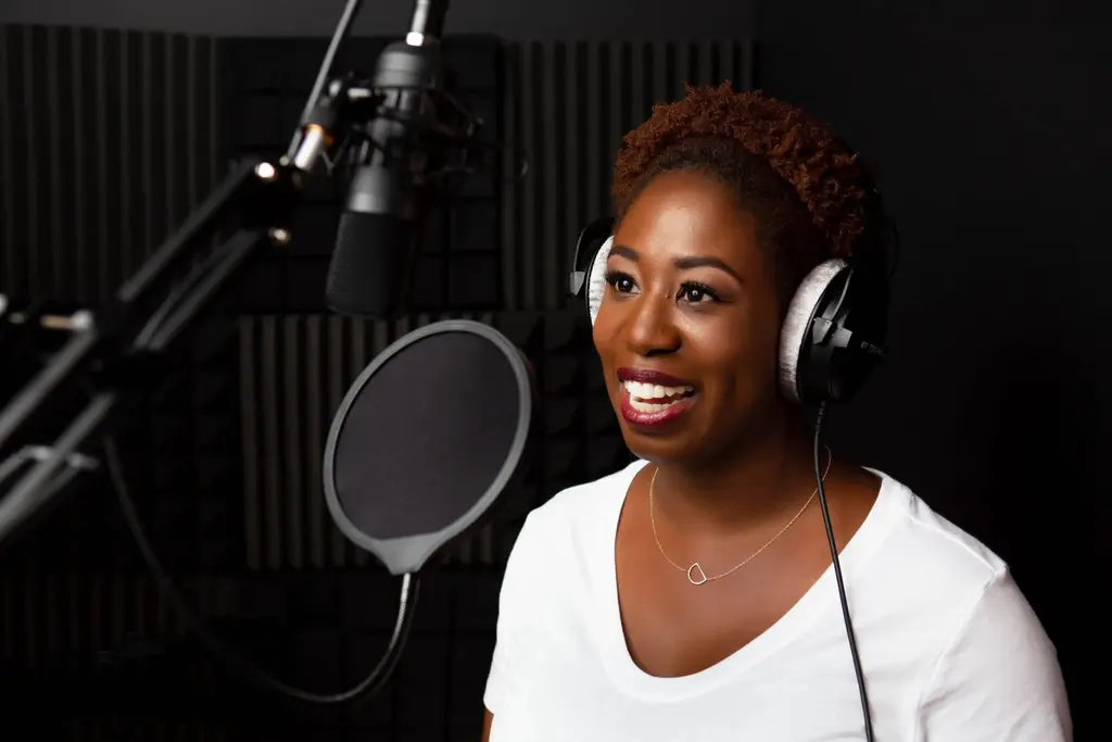 Voice Actor Danielle Famble Speaking into a Microphone with a smile